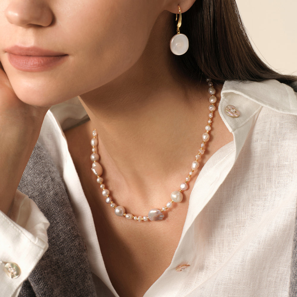 Model wearing baroque mixed freshwater pearl gradient necklace in 925 sterling silver, styled with coin pearl earrings