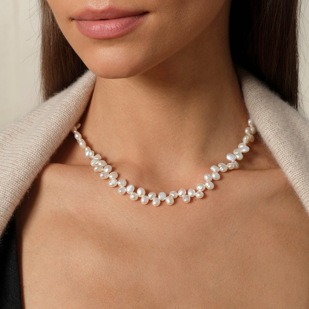 Model wearing freshwater pearl butterfly clasp necklace in 925 sterling silver, front neck view