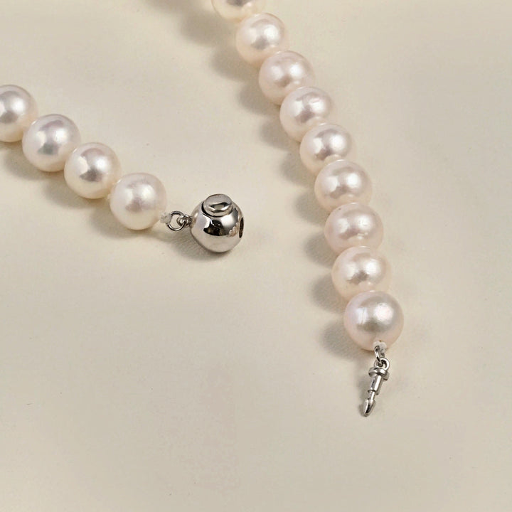 Detail shot of 8mm polished silver ball clasp on freshwater pearl strand necklace