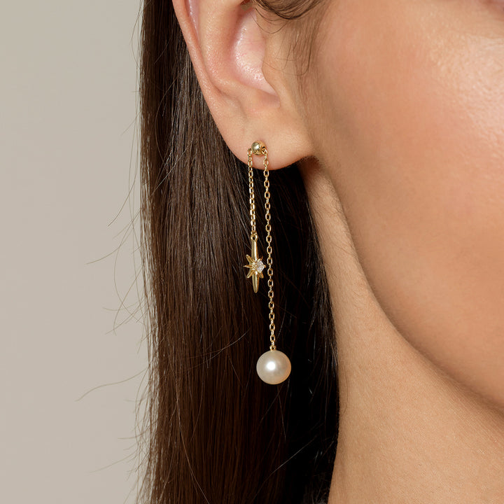 Side profile close-up of gold plating north star freshwater pearl chain drop earring on model