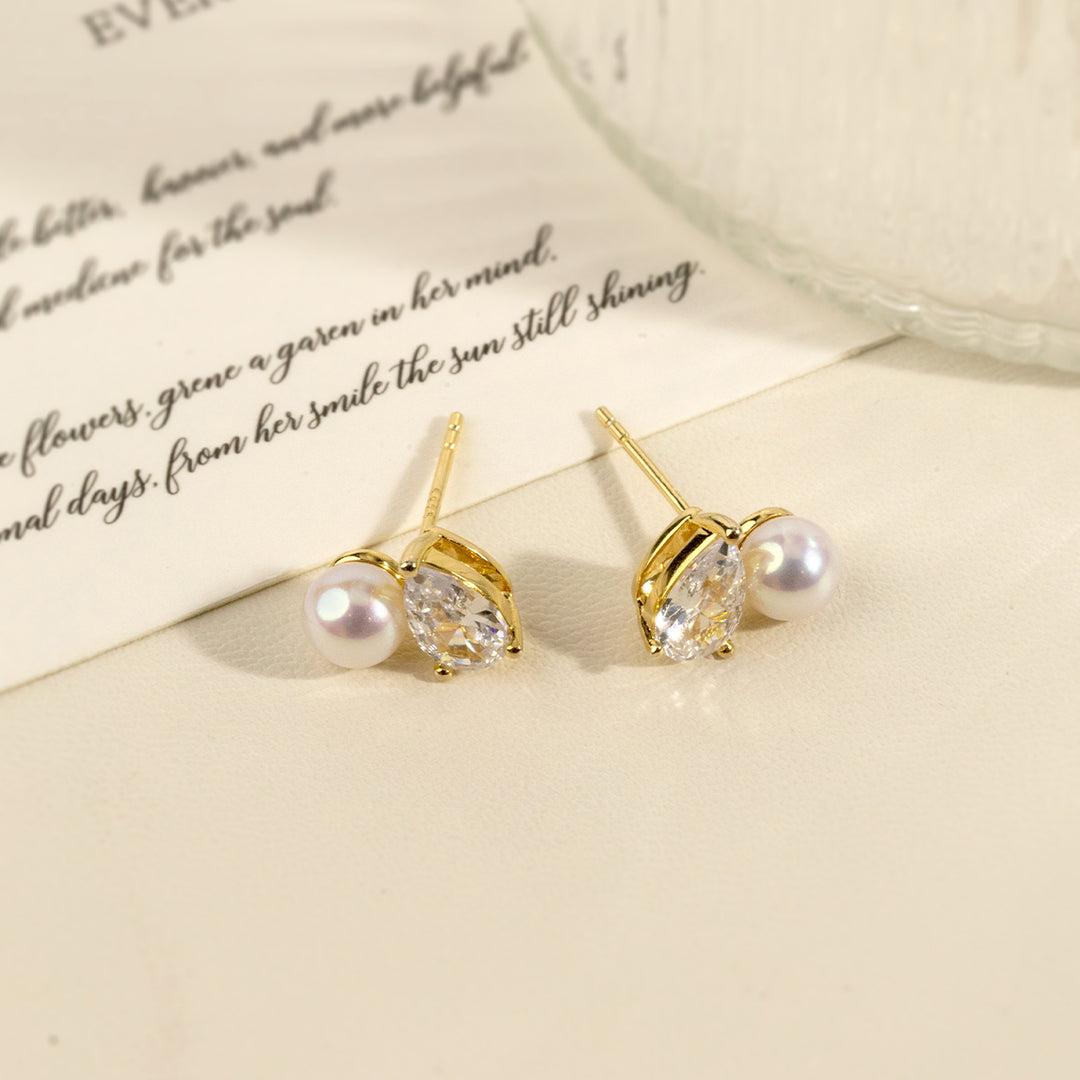Gold plating freshwater pearl pear-cut CZ stud earrings on paper flatlay with handwritten text background