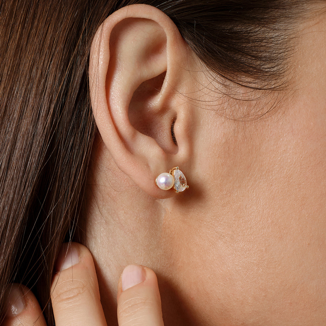 Close-up of model wearing gold plating pearl CZ stud earring, hand near ear