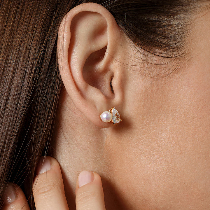 Close-up of model wearing gold plating pearl CZ stud earring, hand near ear