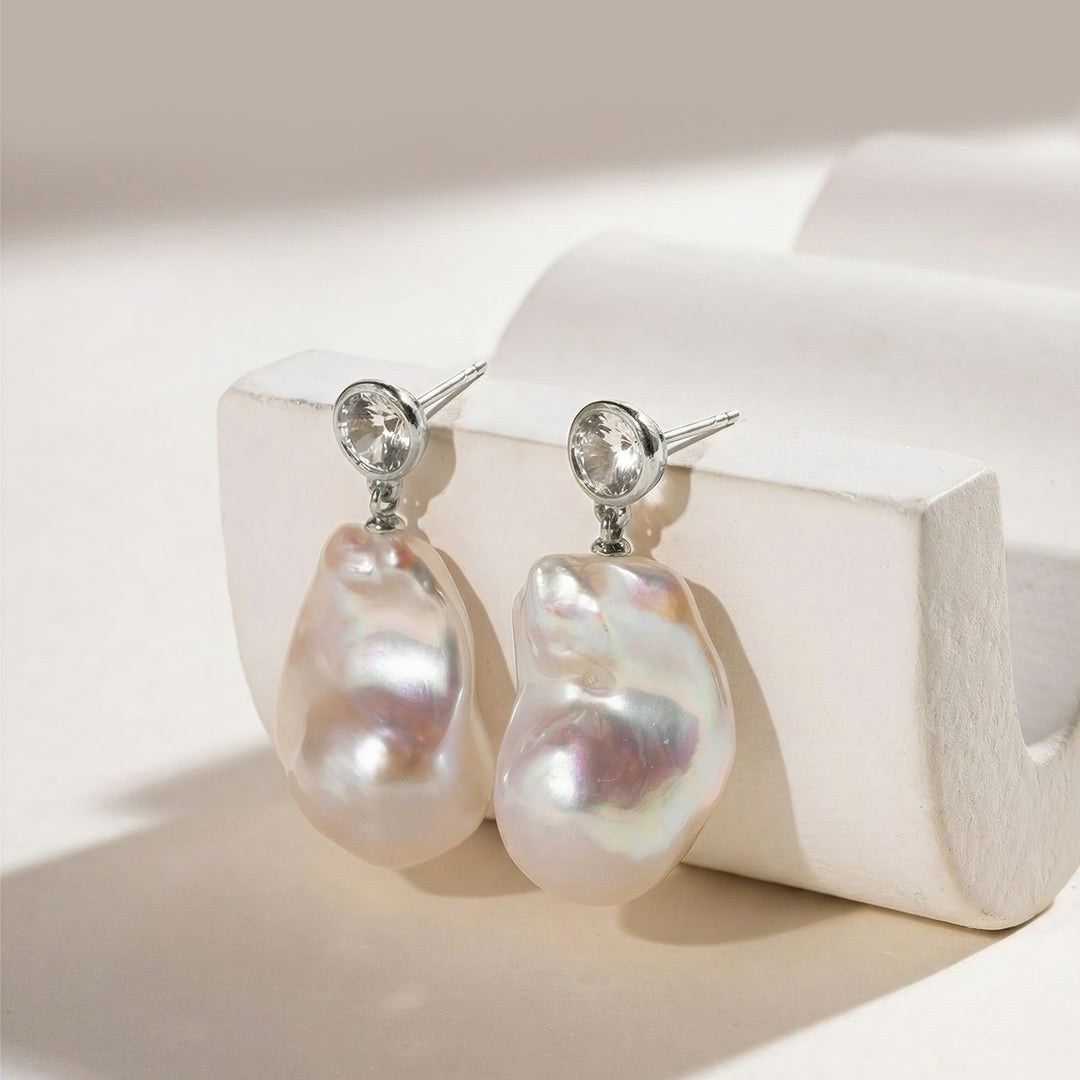 Baroque freshwater pearl drop earrings with round cubic zirconia stud top, 925 sterling silver, styled on white plaster prop