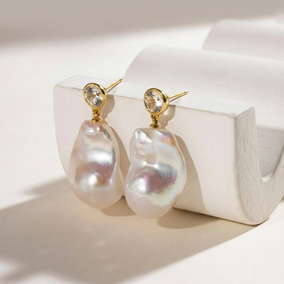 Gold-plated baroque freshwater pearl necklace with CZ accents leaning against white props