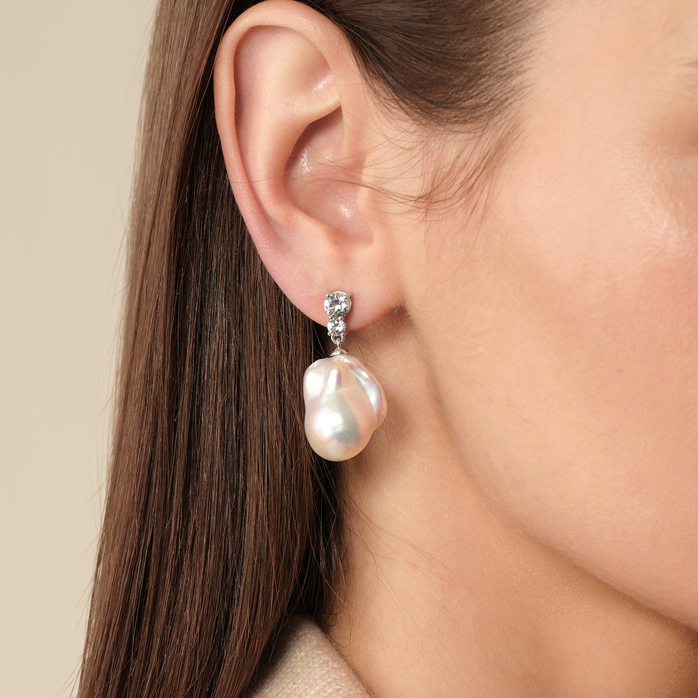 Model wearing 925 sterling silver baroque freshwater pearl double CZ drop earrings, side ear close-up