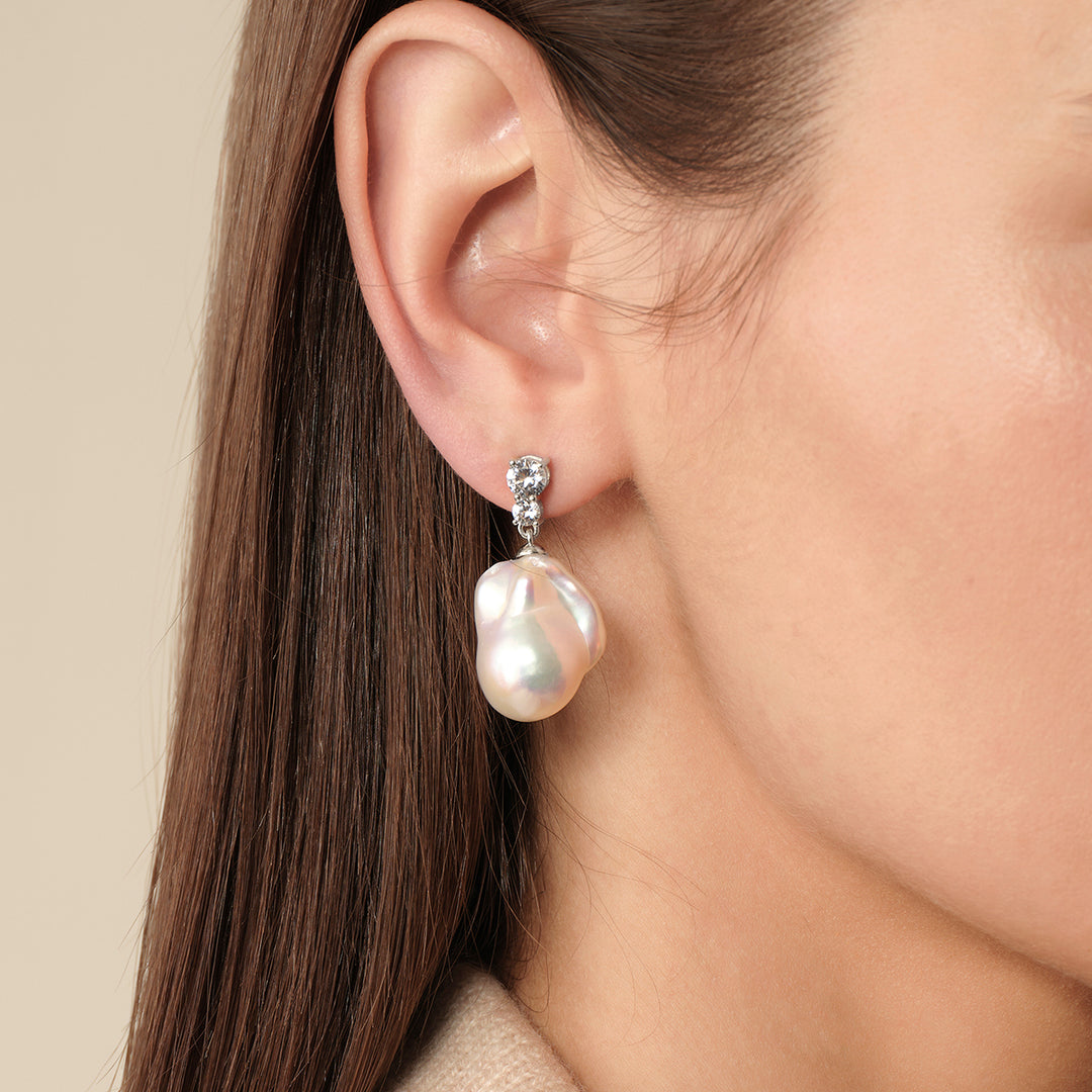 Model wearing 925 sterling silver baroque freshwater pearl double CZ drop earrings, side ear close-up