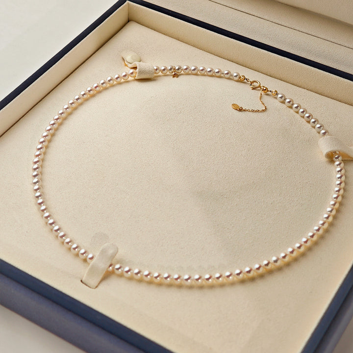 Aurora freshwater pearl gold vermeil strand necklace displayed in HELAS navy velvet gift box with GUILD gem certificate