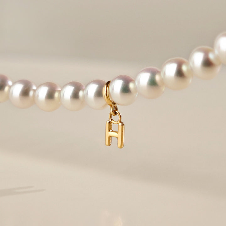 Close-up of gold vermeil H-letter charm pendant detail on Aurora freshwater pearl strand necklace, 925 sterling silver