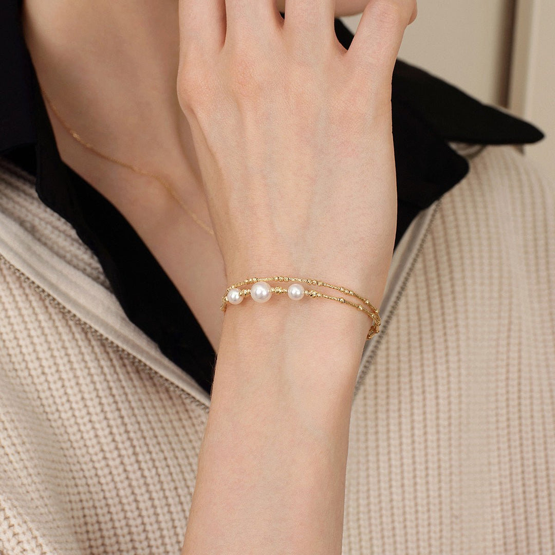 Woman wearing a gold vermeil freshwater pearl double-layer stretch bracelet