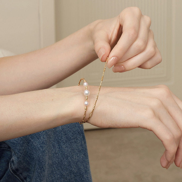 Woman showing the stretch fit of a gold vermeil freshwater pearl bracelet