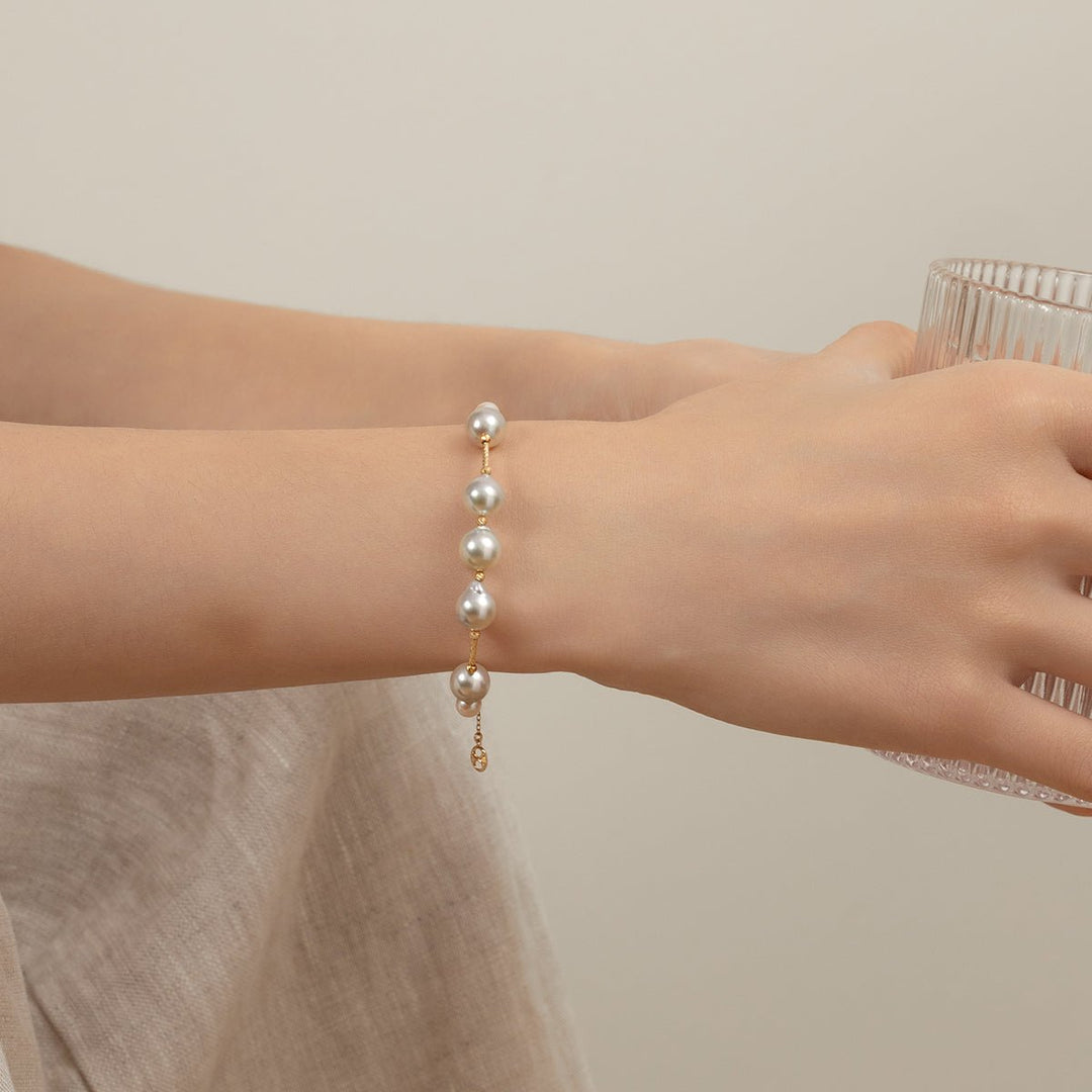Woman wearing a gold vermeil baroque pearl bracelet, side view showing extender