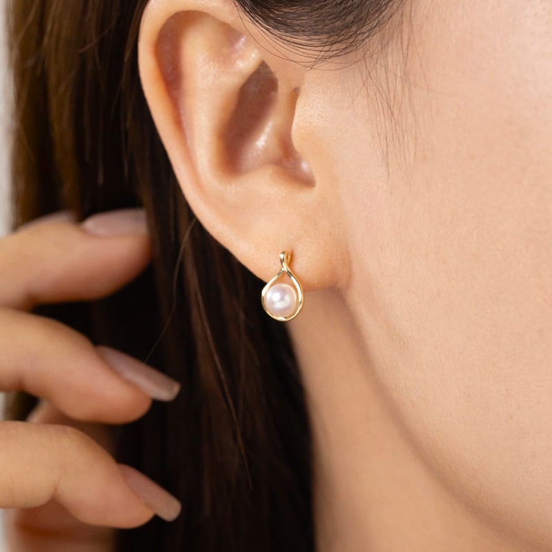 Model wearing freshwater pearl gold vermeil teardrop stud earring in 925 sterling silver, ear close-up