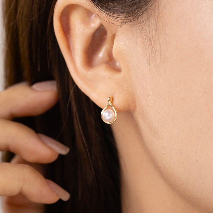 Model wearing freshwater pearl gold vermeil teardrop stud earring in 925 sterling silver, ear close-up