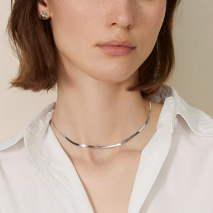 18K solid gold herringbone necklace from Fine Line Collection, showcasing sleek, flat chain design on a neutral background.