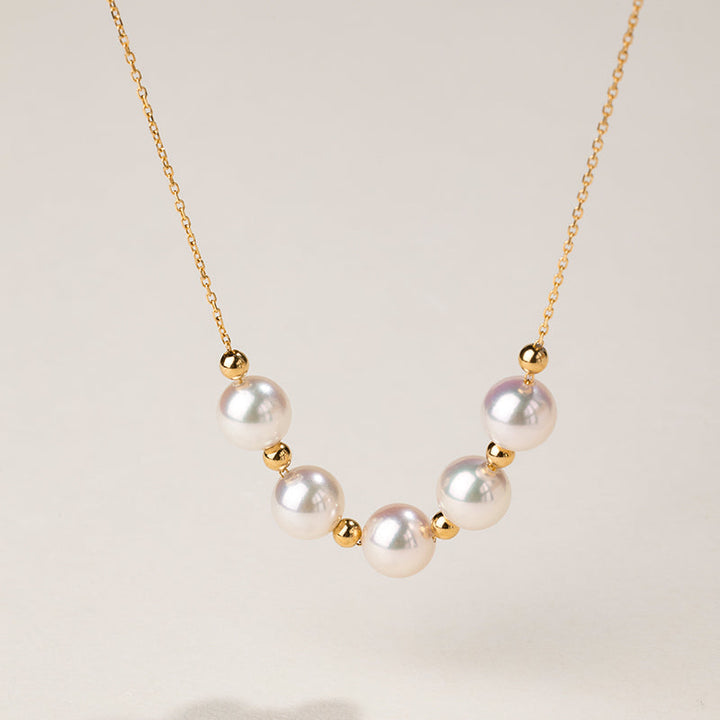 Akoya 18k yellow gold baby's breath smile necklace from Fine Line Collection, featuring delicate gold chain and tiny floral accents.