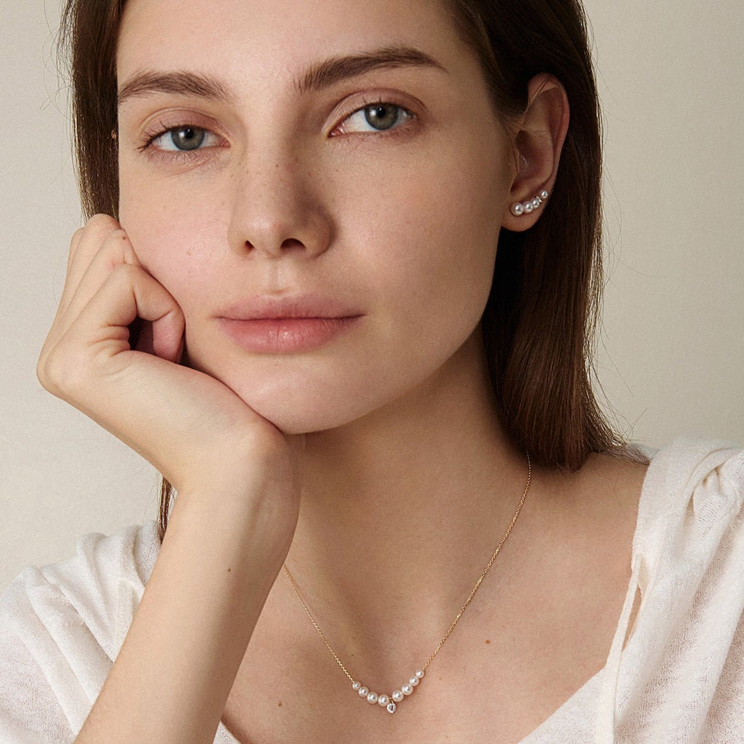 Model wearing freshwater pearl gold vermeil ear climber earrings with matching necklace, front view