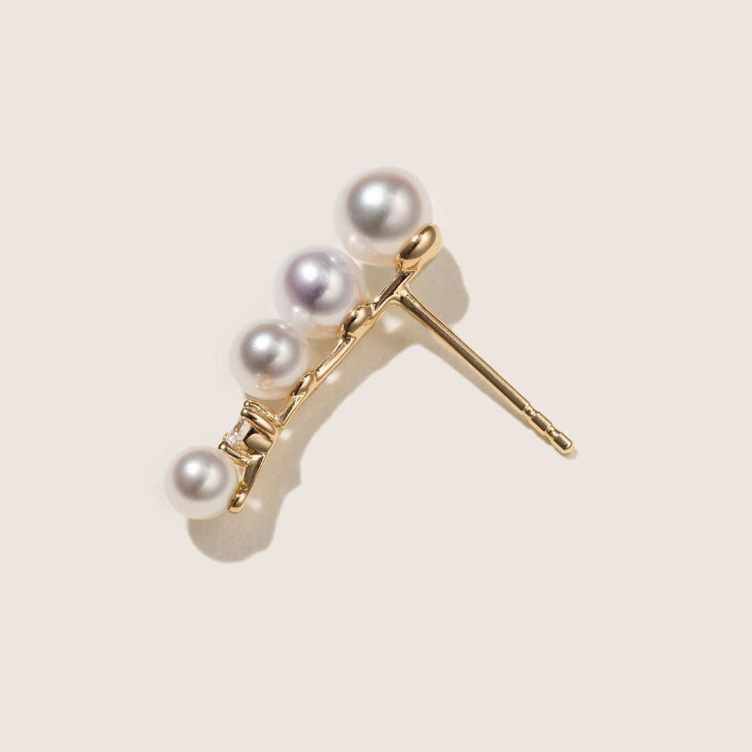 Close-up of freshwater pearl graduating sizes and lab-grown diamond on gold vermeil ear climber, angled detail