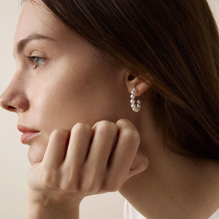 Woman wearing gold vermeil freshwater pearl circle earrings, front face view