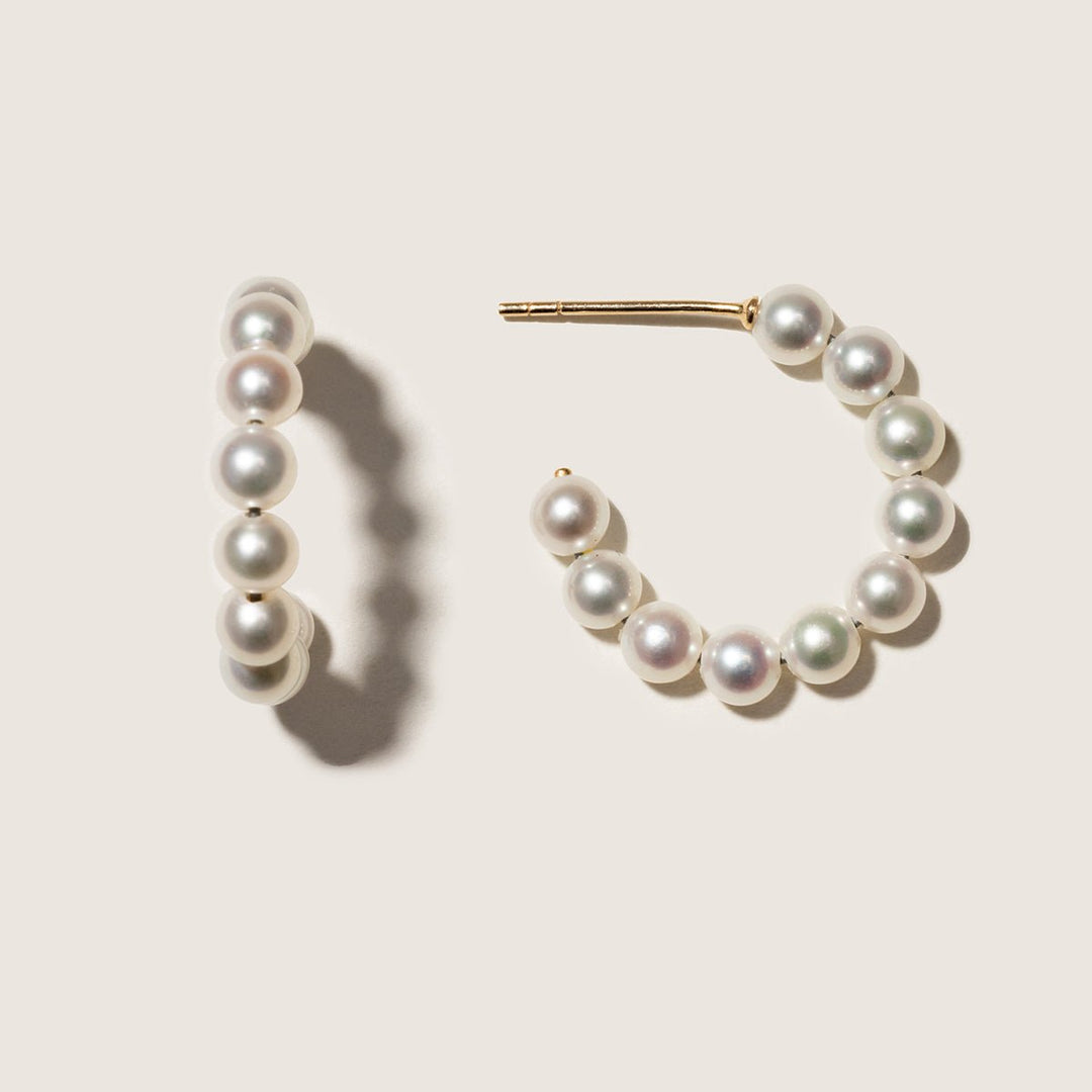 Gold vermeil freshwater pearl circle hoop earrings, pair on a neutral surface