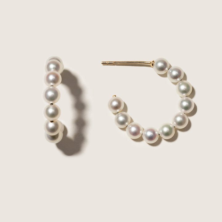 Gold vermeil freshwater pearl circle hoop earrings, pair on a neutral surface