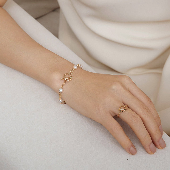 Model wearing freshwater pearl gold vermeil toggle chain bracelet paired with matching ring in 925 sterling silver