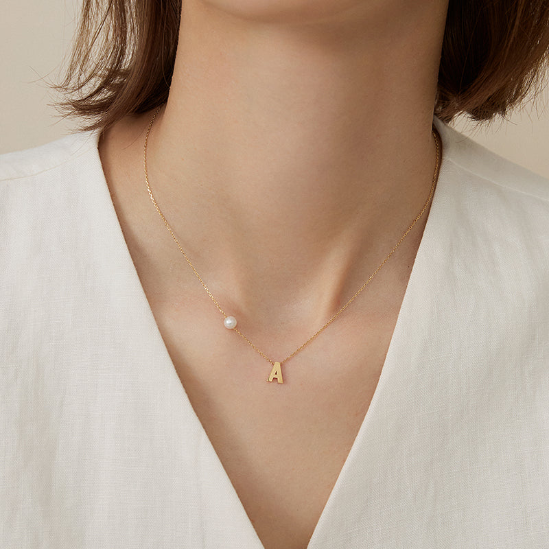 Akoya saltwater pearl 18K gold hanging initials necklace by H Collection, featuring a pearl pendant and custom initials.