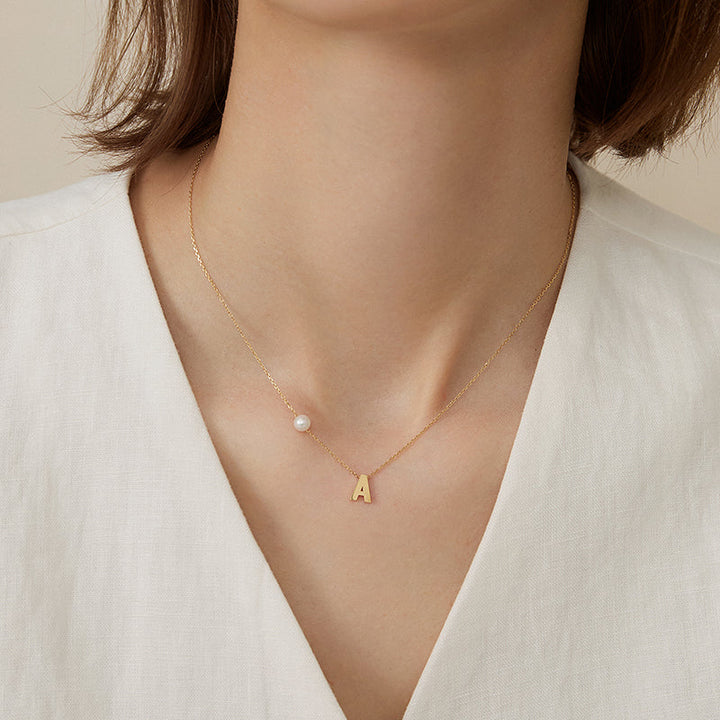 Akoya saltwater pearl 18K gold hanging initials necklace by H Collection, featuring a pearl pendant and custom initials.