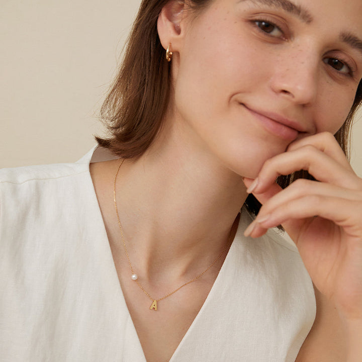 Akoya saltwater pearl 18K gold hanging initials necklace with customizable charms, elegant jewelry by H Collection.