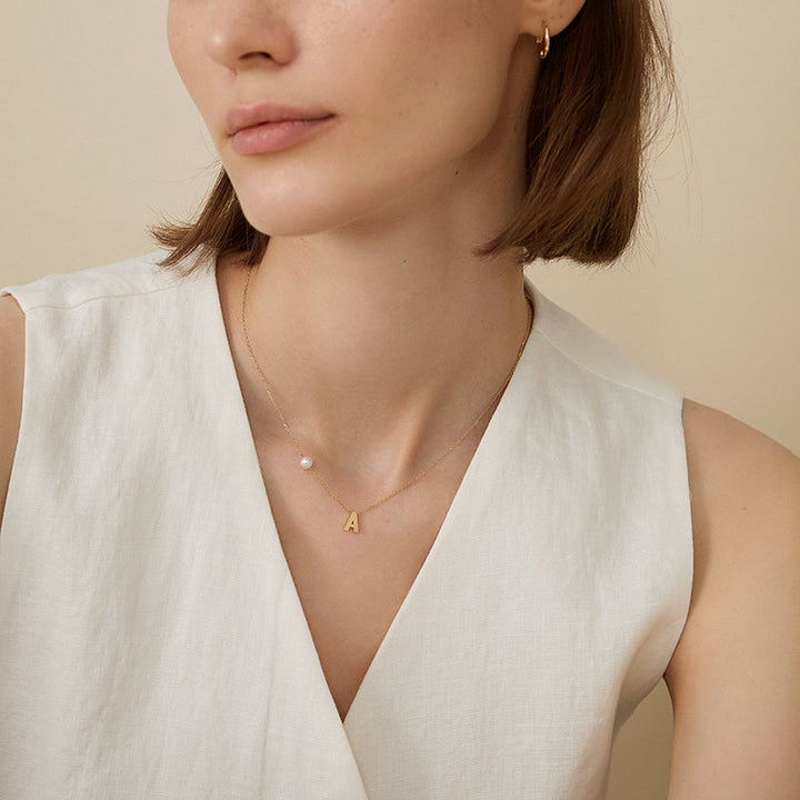 Akoya saltwater pearl and 18K gold hanging necklace with custom initials, featuring elegant pearl and gold chain design.