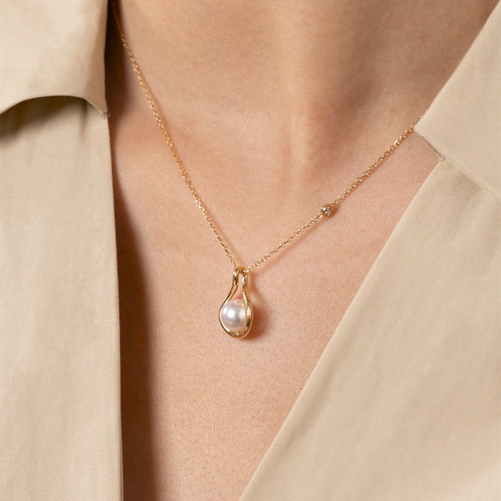 Side view of model wearing freshwater pearl gold vermeil teardrop pendant necklace