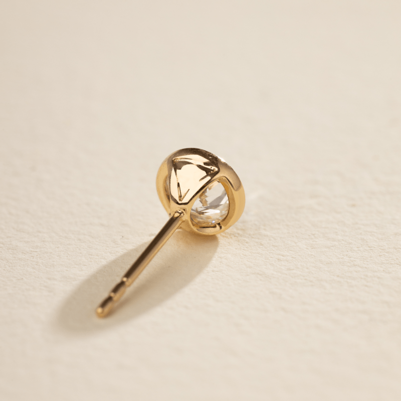 Lab-grown diamond gold vermeil bezel set stud earring, single piece angled close-up detail