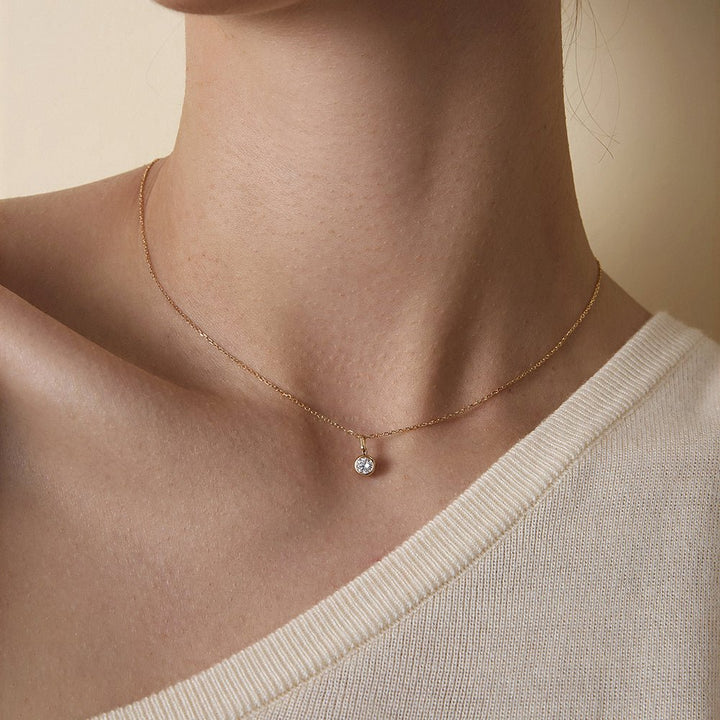 Model wearing lab-grown diamond gold vermeil bezel pendant necklace with V-neck knit