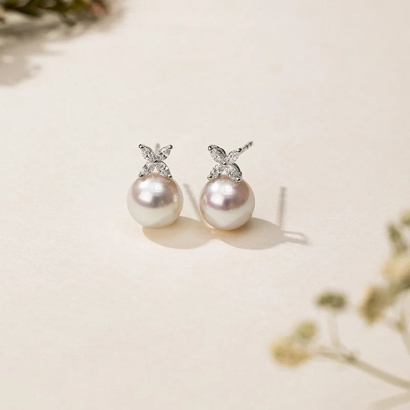 Freshwater pearl flower stud earrings with diamond cluster on a neutral background