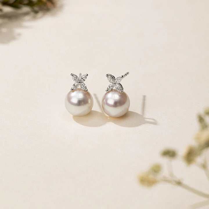 Freshwater pearl flower stud earrings with diamond cluster on a neutral background