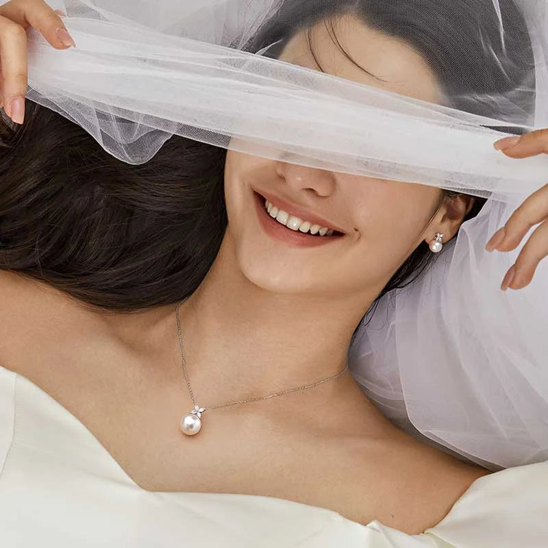 Model wearing freshwater pearl sterling silver diamond flower pendant necklace in bridal styling