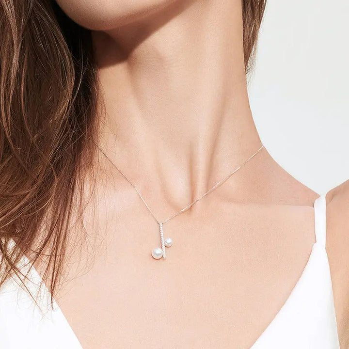Close-up of AAAAA freshwater pearl and lab-grown diamond note pendant on sterling silver chain