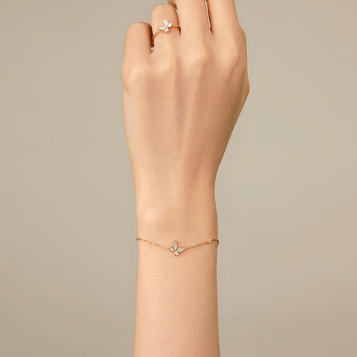 Close-up of model's wrist wearing mother-of-pearl gold vermeil butterfly bracelet paired with matching butterfly ring