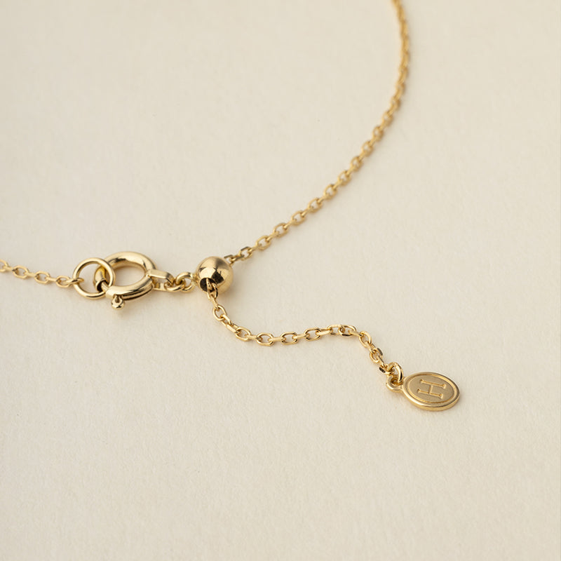 Detail of spring ring clasp, adjustable bead and HELAS round logo tag on gold vermeil sterling silver bracelet