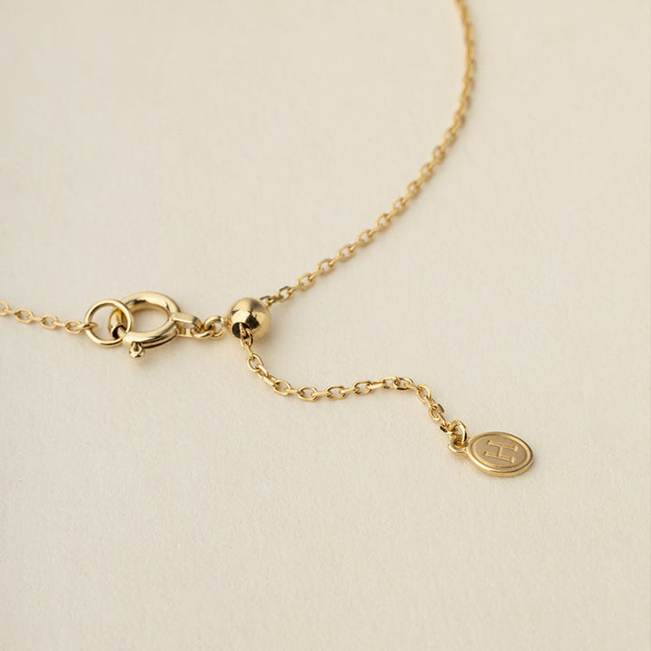 Detail of spring ring clasp, adjustable bead and HELAS round logo tag on gold vermeil sterling silver bracelet