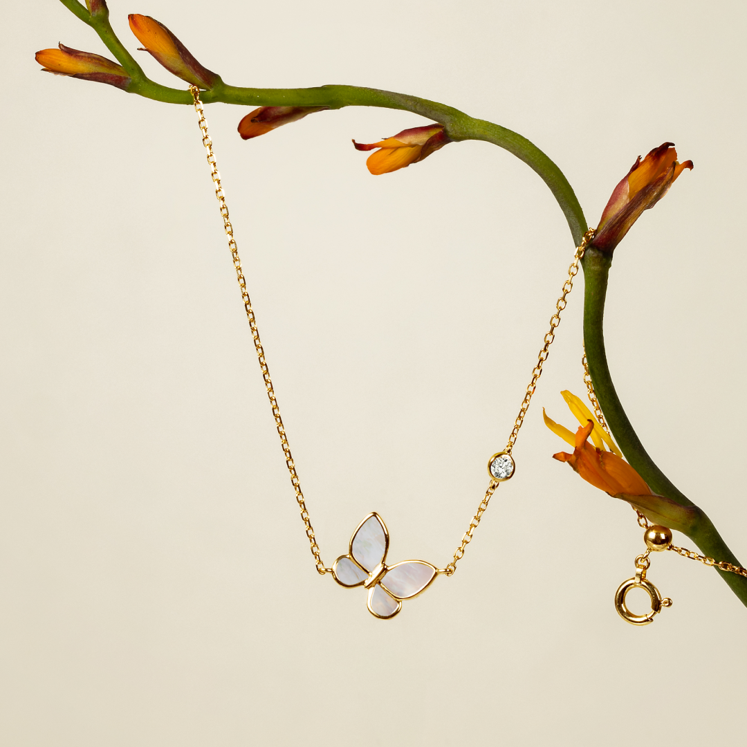 Gold vermeil sterling silver mother-of-pearl butterfly necklace with lab-grown diamond, styled with a flower stem