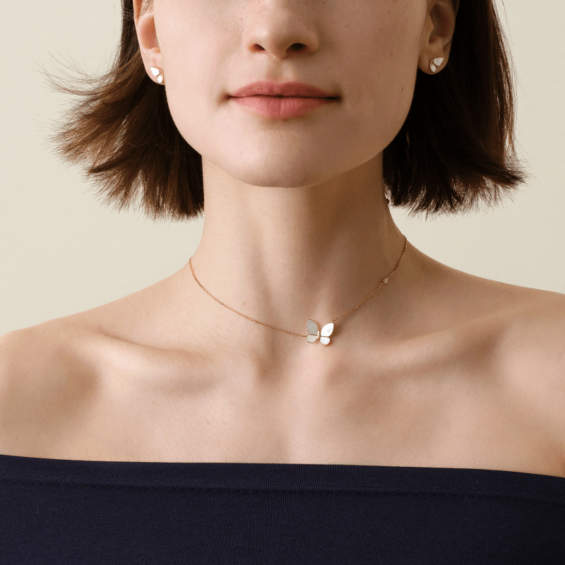Woman wearing a gold vermeil mother-of-pearl butterfly pendant necklace