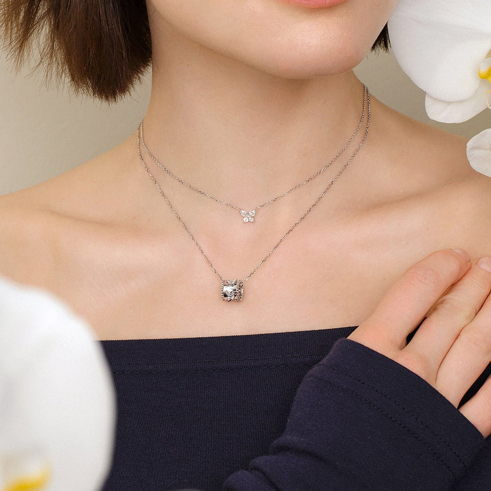 Model wearing lab-grown diamond butterfly pendant necklace layered with diamond butterfly station necklace