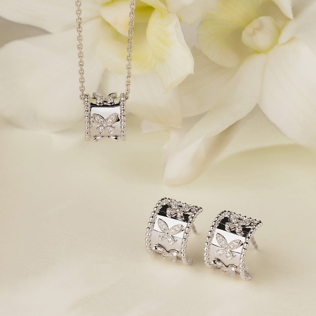 Lab-grown diamond kaleidoscope butterfly pendant necklace and matching earrings set styled with white flowers