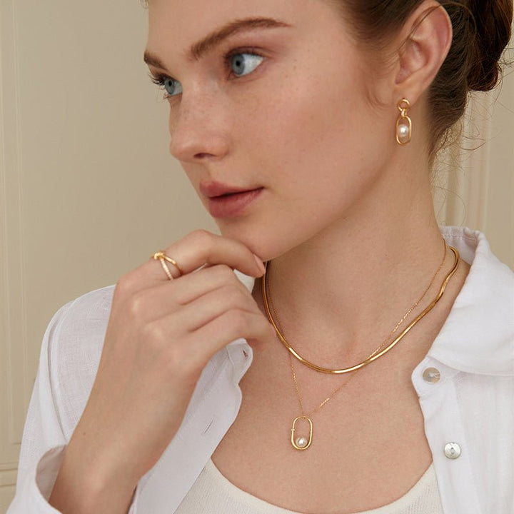 Model wearing freshwater pearl gold vermeil hoop earrings styled with matching necklace and ring