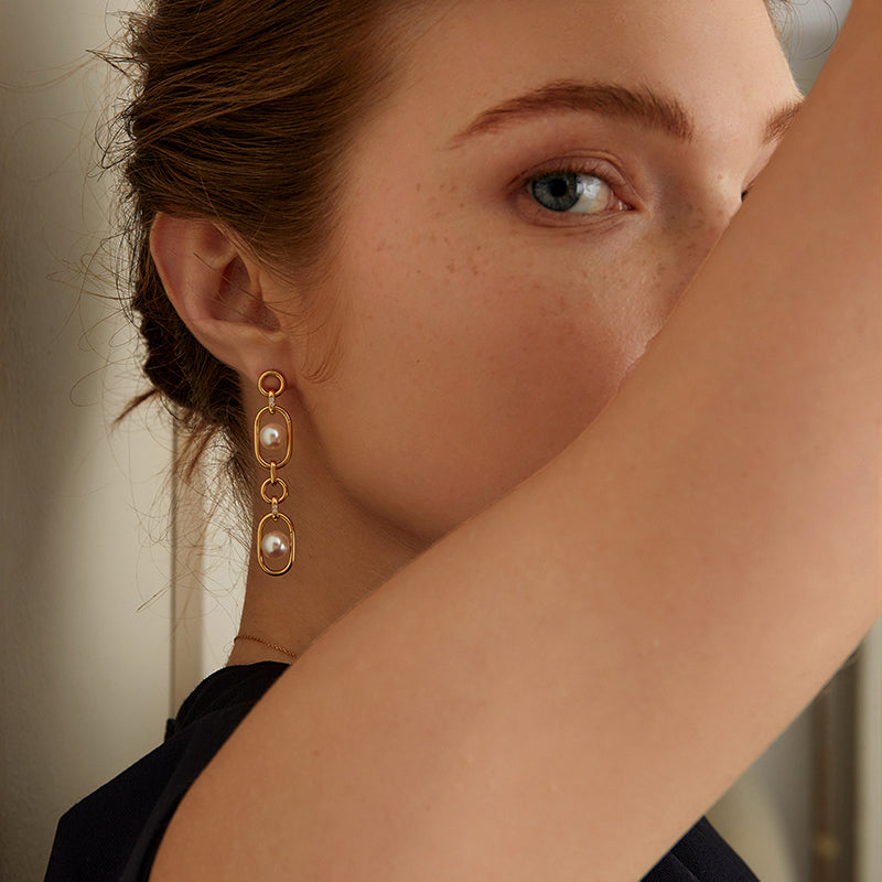 Model wearing freshwater AAAAA pearl gold vermeil long-style double-link oval drop earrings, close-up