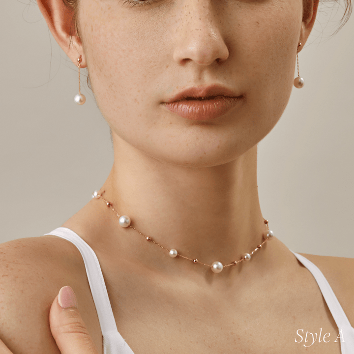Model wearing freshwater pearl gold vermeil station necklace, front view with white top