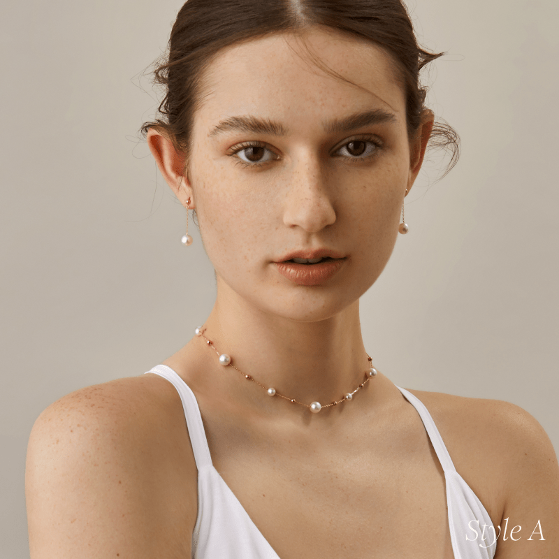 Portrait of model wearing freshwater pearl gold vermeil station necklace with white top