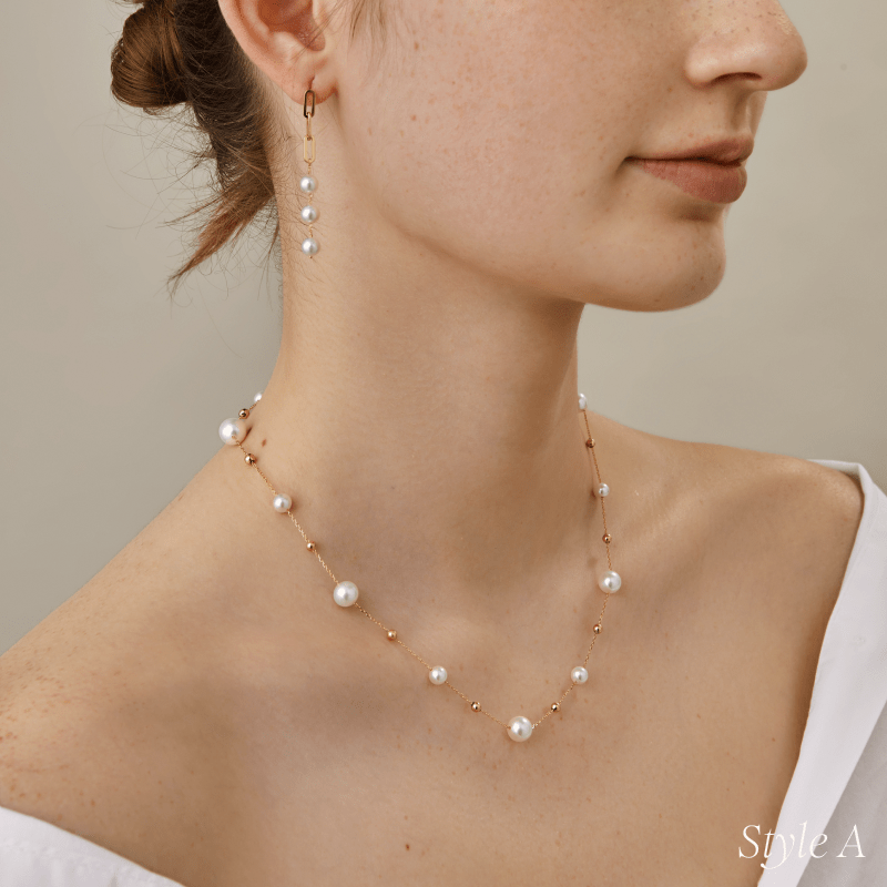 Side view of model wearing freshwater pearl gold vermeil station necklace styled with drop earrings