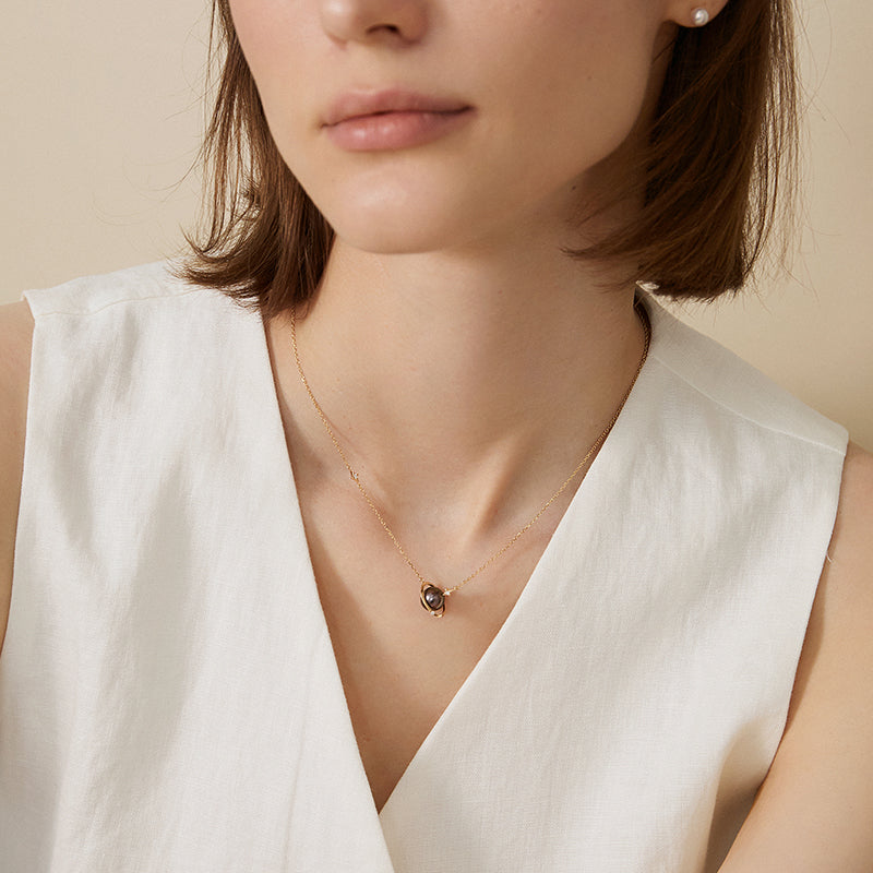 Saltwater pearl 18K gold diamond planet necklace from Star Trails Collection, featuring a delicate pearl and sparkling diamond accents.